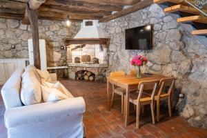 a living room with a table and a stone wall at Familija Lovrinovi Retreat - Relax&Reconnect in Zvoneće
