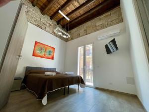 Un dormitorio con una cama y un televisor en la pared. en Baron’s Suites, en Palermo