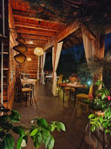 a restaurant with tables and chairs and plants at Czarna Owca in Istebna