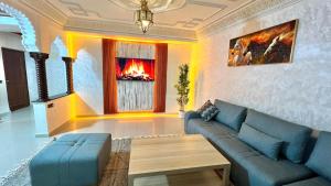 salon z niebieską kanapą i kominkiem w obiekcie sejour avec Jacuzzi et terrase au coeur du gueliz w Marakeszu