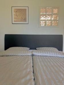 a bed with white sheets in a bedroom with a window at Lauttasaari Studio in Helsinki
