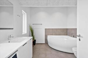 Un baño blanco con bañera y lavabo. en 914-Hvide-Sande-Langsand-196-1-sal, en Hvide Sande 26 fotos más