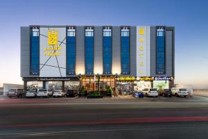 Un hotel con coches aparcados delante. en فندق القصر - الطائف, en Taif