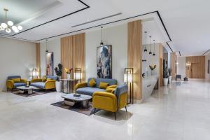 a lobby with yellow and blue chairs and a table at Al Qasr Hotel Taif in Taif +16 photos