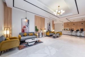 a living room with couches and a table and a kitchen at Al Qasr Hotel Taif in Taif