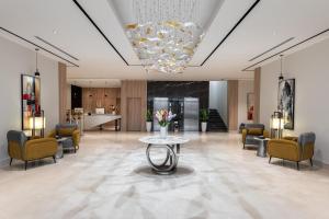 a lobby with a table and chairs and a chandelier at Al Qasr Hotel Taif in Taif