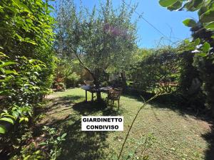 a sign in a yard with a table and a chair at Acquaviva - By Ligooria in Tovo San Giacomo
