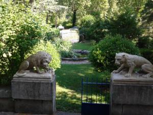 Dos estatuas de leones sentados en lo alto de una valla en Domaine du Vern, en Saint-Affrique