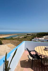 a table and chairs on a balcony with a view of the ocean at Chez abdelilah in Oualidia +9 photos