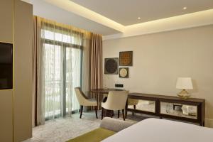 una camera d'albergo con tavolo e sala da pranzo di The Alexander, a Luxury Collection Hotel, Yerevan a Yerevan