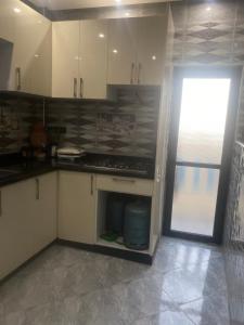 a kitchen with a stove and an open refrigerator at Appartement complet meublé 2 chambres in Tamraght Ouzdar