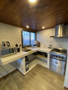a kitchen with a sink and a stove at Cabañas boutique Huella Andina in Potrerillos