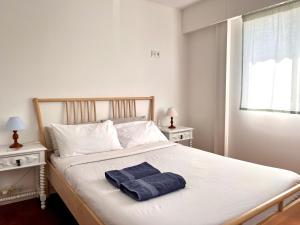 a bedroom with a bed with a towel on it at Hostel do Alto - Fão in Esposende