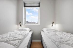 two beds in a room with a window at 776-Hvide-Sande-Norregade-2-nr-27 in Hvide Sande