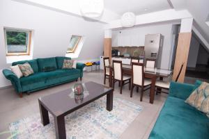 een woonkamer met een groene bank en een tafel bij WILLA DobraNocka in Szklarska Poręba