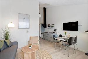 a living room with a couch and a table and a kitchen at 7780-Hvide-Sande-Norregade-2-nr-10 in Hvide Sande