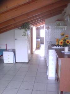 una cucina con frigorifero e piano di lavoro di Mansarda Del Falco a Punta Braccetto