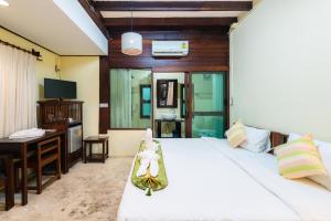 Un dormitorio con una cama, un escritorio y una computadora. en Rompo Boutique Hotel, en Chiang Mai