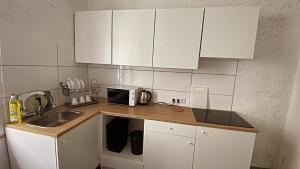 a kitchen counter with a sink and white cabinets at Appartment Сoppenbrügge in Coppenbrügge