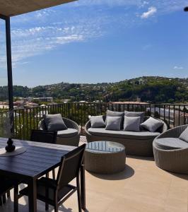 a patio with couches and a table and chairs at Rioni & Bagrati Panorama in Kutaisi +6 photos