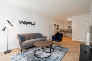 a living room with a couch and a table at Birchgrove Christchurch Apartments Exclusively for 65s in Leatherhead
