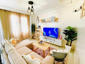 a living room with a couch and a tv at Chic Design Stay With a Chocolate Welcome Gift in Agadir