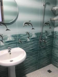 un bagno con lavandino e delfini sul muro di THEODORE-Hotel a Kobuleti Altre 37 foto