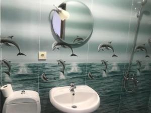 un bagno con lavandino e delfini sul muro di THEODORE-Hotel a Kobuleti