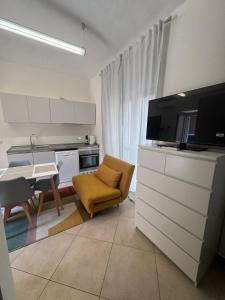 sala de estar con cocina con mesa y TV en Casa Dora, en Turín