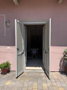 Una puerta abierta a una casa rosa con una mesa. en Casa Dora, en Turín 1 foto más