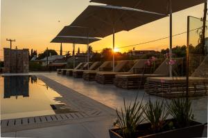 a row of chairs and umbrellas on a patio at Ampeli Villas in Stoupa