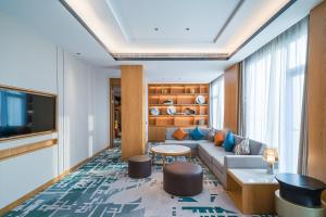 a living room with a couch and a tv at Crowne Plaza Huzhou by IHG in Huzhou