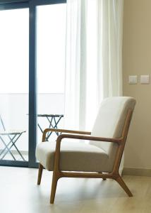 a chair sitting in front of a window at Casa Ilda in Olhão