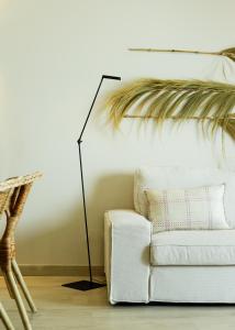 a living room with a white couch and a floor lamp at Casa Ilda in Olhão