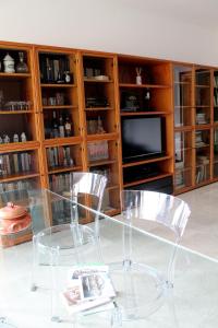 einem Glastisch mit 2 Stühlen und einem TV in der Unterkunft COLOR HOUSE- Lecco's Lake in Lecco