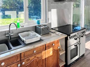 a kitchen with a sink and a stove top oven at Pillango in Cowes +13 photos
