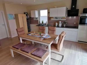 a kitchen with a wooden dining table and chairs at Ferienhaus Seglerblick am Achterwasser in Ziemitz