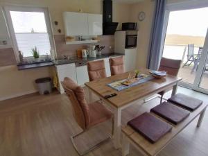 a kitchen and dining room with a wooden table at Ferienhaus Seglerblick am Achterwasser in Ziemitz +27 photos