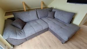 a large gray couch in a living room at Ferienwohnung OG Seglerblick am Achterwasser in Ziemitz