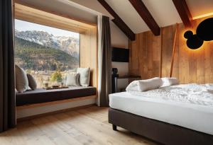 une chambre avec deux lits et une grande fenêtre dans l'établissement Residence Hotel Eden - Family & Wellness Resort, à Andalo 100 autres photos