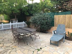 a patio with a table and chairs and a fence at Studio meublé au calme avec terrasse et climatiseur mobile in Fréjus