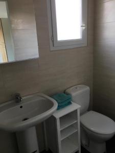a bathroom with a sink and a toilet and a mirror at Studio meublé au calme avec terrasse et climatiseur mobile in Fréjus