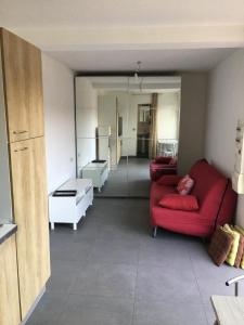 a living room with two red couches in a room at Studio meublé au calme avec terrasse et climatiseur mobile in Fréjus