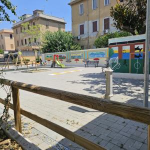 - un parc avec une aire de jeux dotée de toboggans et de bancs dans l'établissement Appartamenti Ohana, à Reggio de Calabre