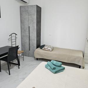 Cette chambre comprend deux lits, un bureau et une chaise. dans l'établissement Appartamenti Ohana, à Reggio de Calabre
