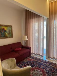 a living room with a red couch and a chair at Limonaieincentro in San Benedetto del Tronto