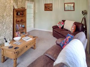 a living room with two couches and a coffee table at Ivy Cottage in Cumberworth