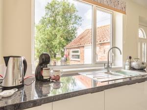 a kitchen with a sink and a window at Ivy Cottage in Cumberworth
