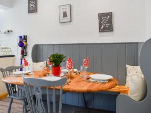 mesa de madera con sillas y comedor en Trelawney Bungalow, en Callington