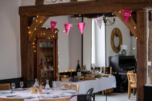 a dining room with a table with white table cloth and pink flags at Rayon de sologne, Manoir 38 à 49 personnes 30 min zoo beauval, chambord, center parc in Langon